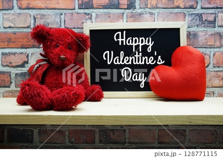 Happy Valentines Day text on chalkboard with teddy bear on wooden background 128771115