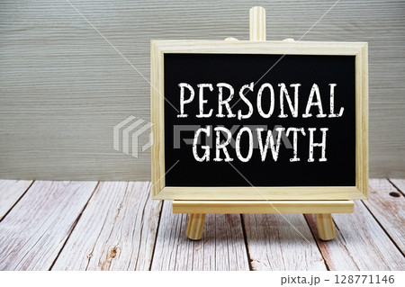 Personal Growth text written on chalkboard with easel on wooden background 128771146