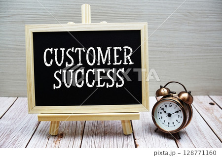 Customer Success text written on chalkboard with alarm clock on wooden background 128771160