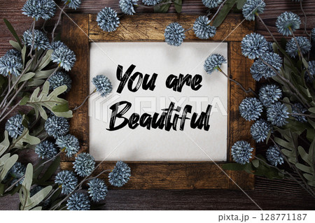 You are Beautiful text with flowers decoration on wooden background You are Beautiful text with flowers decoration on wooden background 128771187