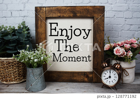 Enjoy The Moment Motivational and Inspirational quotes on wooden background 128771192