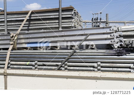 足場の組み立て 資材をトラックから降ろして準備する職人 足場の組み立て 資材をトラックから降ろして準備する職人 128771225