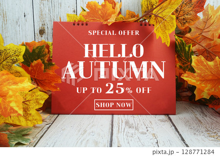 Hello Autumn Sale 25% text with maple leaf decorated on wooden background 128771284