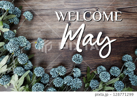 Welcome May text with flowers decoration on wooden background Welcome May text with flowers decoration on wooden background 128771299