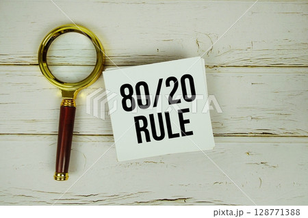 80/20 Rule text message on paper with magnifying glass on wooden background 80/20 Rule text message on paper with magnifying glass on wooden background 128771388