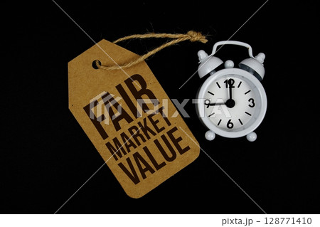 Fair Market Value text on price tag with alarm clock on black background Fair Market Value text on price tag with alarm clock on black background 128771410