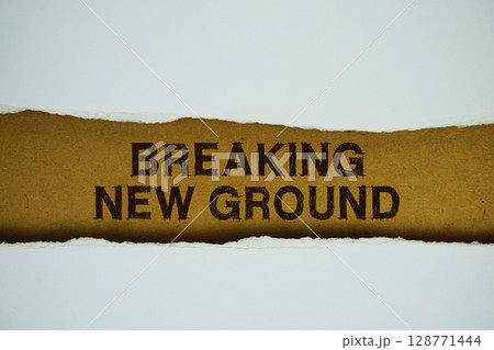 Breaking New Ground text on paper craft with white paper torn ripped of horizontal 128771444
