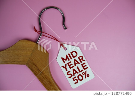 Mid Year Sale 50% off text on price tag label with Clothes hanger fashion shopping concept Mid Year Sale 50% off text on price tag label with Clothes hanger fashion shopping concept 128771490
