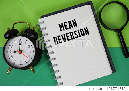 Mean Reversion text written on notebook paper with alarm clock and magnifying glass 128771712