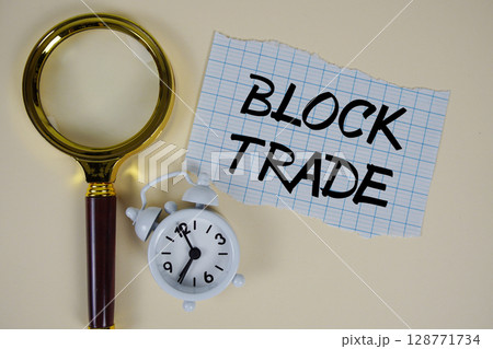 Block Trade text written on paper with magnifying glass and alarm clock 128771734