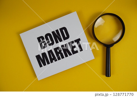 Bond Market letters with magnifying glass flat lay on yellow background Bond Market letters with magnifying glass flat lay on yellow background 128771770
