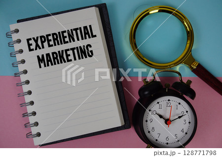 Experiential Marketing text written on notebook paper with magnifying glass and alarm clock Experiential Marketing text written on notebook paper with magnifying glass and alarm clock 128771798