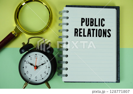 Public Relations text written on notebook paper with magnifying glass and alarm clock 128771807