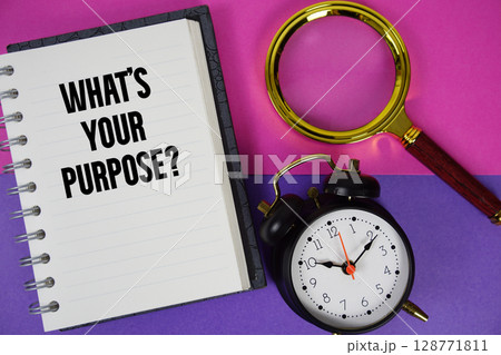 What's Your Purpose? text written on notebook paper with magnifying glass and alarm clock 128771811