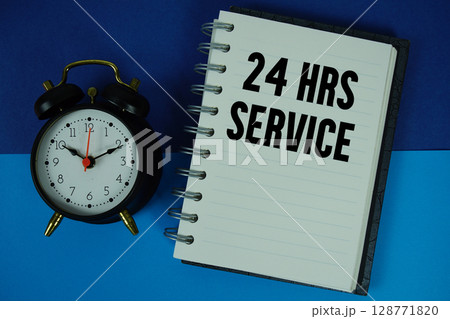 24 Hrs Service text written on notebook paper with alarm clock 128771820