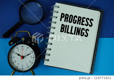 Progress Billings text written on notebook paper with alarm clock 128771822