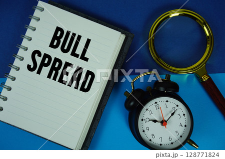 Bull Spread text written on notebook paper with magnifying glass and alarm clock 128771824