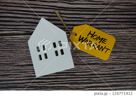Home Warrant text on price tag with white house model flat lay on wooden background 128771912