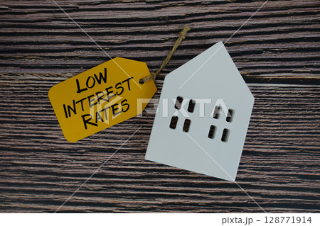 Low Interest Rates text on price tag with white house model flat lay on wooden background 128771914