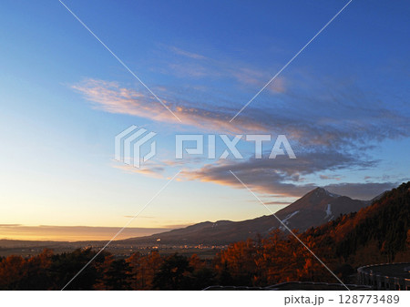 晩秋、僅かに冠雪した磐梯山と夕日でピンク色に染まったℤ型の雲が青空に印象的で綺麗だ。 128773489