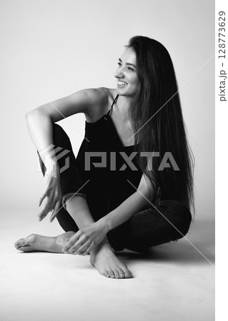 Studio portrait of beautiful longhair woman with jeans 128773629