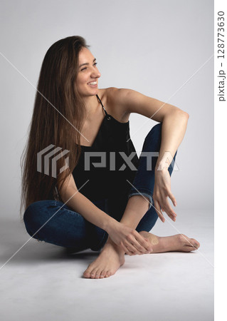 Studio portrait of beautiful longhair woman with jeans 128773630