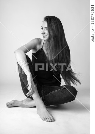 Studio portrait of beautiful longhair woman with jeans 128773631