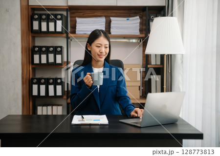 Business woman using tablet and laptop for doing math finance on an office desk, tax, report, accounting, statistics, and analytical research concept 128773813