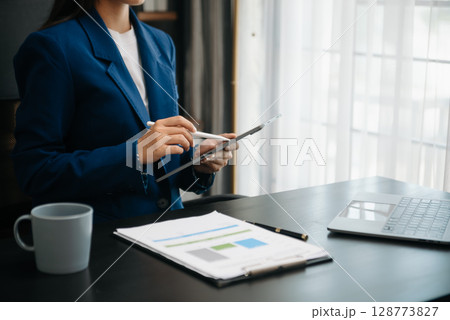 Woman freelancer is working her job on computer tablet and laptop Doing accounting analysis report real estate investment data, Financial 128773827