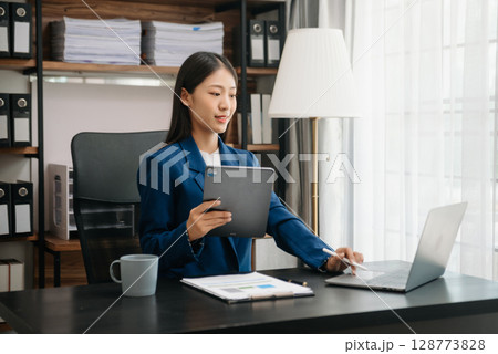 Woman freelancer is working her job on computer tablet and laptop Doing accounting analysis report real estate investment data, Financial 128773828