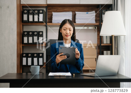 Woman freelancer is working her job on computer tablet and laptop Doing accounting analysis report real estate investment data, Financial 128773829