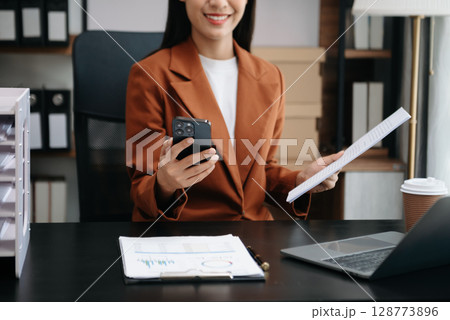 Business woman using tablet and laptop for doing math finance on an office desk, tax, report, accounting, statistics, and analytical research concept 128773896
