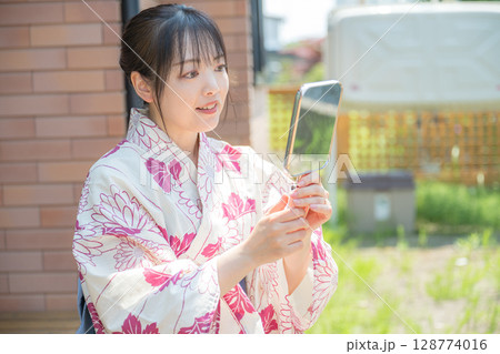 笑顔で鏡を見る浴衣女性 笑顔で鏡を見る浴衣女性 128774016