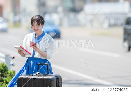 笑顔でパスポートを観る女性 128774025