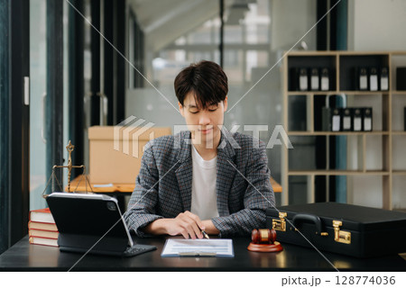 justice and law concept.Male judge in a courtroom on table and Counselor or Male lawyer working in office. justice and law concept.Male judge in a courtroom on table and Counselor or Male lawyer working in office. 128774036