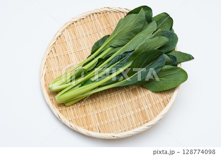新鮮な小松菜をざるに盛った白背景の写真 128774098
