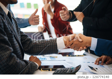 business people shaking hands during a meeting in modern office 128774140