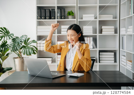 Asian business woman are delighted and happy with the work they do on their tablet, laptop and taking notes at office. Asian business woman are delighted and happy with the work they do on their tablet, laptop and taking notes at office. 128774584