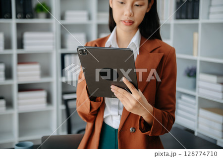 Working Process in Modern Office. Young Woman Account Manager Working at Table with New Business Project. Using Contemporary Laptop. 128774710