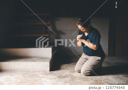 Female kneeling down praying for worship God at home. Christians pray to jesus christ for calmness. people got to quiet place and worship. Christians humble and submit to God. Banner with copy space. 128774848