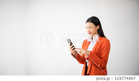 Portrait photo of young beautiful Asian woman feeling happy and holding smart phone, tablet and laptop with black empty screen on white background can use for advertising or product concept. 128774867