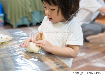 保育園で紙粘土で遊ぶ女の子の幼児 保育園で紙粘土で遊ぶ女の子の幼児 128774989