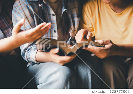 Close up group christians hands pray to God with spiritual faith on holy bible in catholic church. religion worship prayer ask god bless grace jesus believe. Christianity religion prayer holy worship 128775002