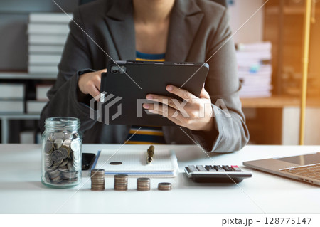Hand putting mix coins and seed in clear bottle and business investment growth concept. at office Hand putting mix coins and seed in clear bottle and business investment growth concept. at office 128775147