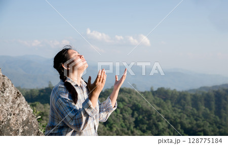 Grateful woman having HOPE praying to God. Spiritual girl smiling to sky. Happy female being thankful. Spiritual girl praying with hope. Positive asian young woman feeling hope and faith looking up. 128775184