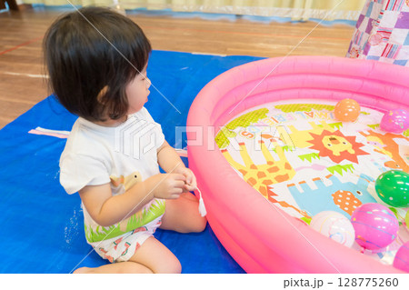 保育園で水ヨーヨー釣りで遊ぶ女の子の幼児 128775260