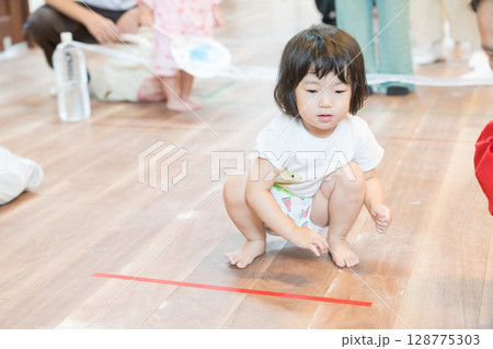 保育園でボーリングゲームで遊ぶ女の子の幼児 保育園でボーリングゲームで遊ぶ女の子の幼児 128775303