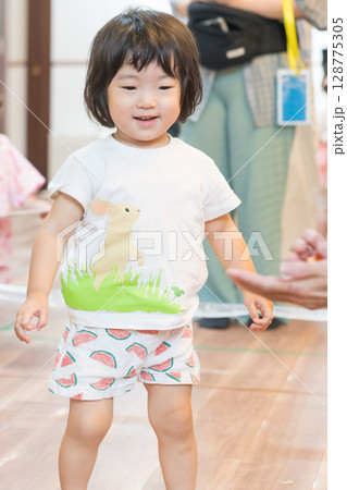 保育園でボーリングゲームで遊ぶ女の子の幼児 保育園でボーリングゲームで遊ぶ女の子の幼児 128775305