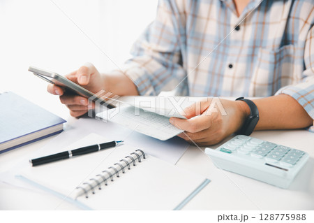 Business hands holding saving account passbook with calculator, account and saving concept. finance effectively, calculate income, track each bill and payment, accounting for bank statements and tax. 128775988