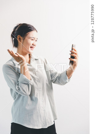 Asian woman rejoicing, looking happy, champion, fist pump gesture, standing over white background. young woman had happy, positive expression on her face, highlighted by bright smile. 128775990
